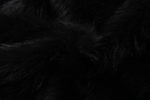 Macro texture of soft black faux fur fabric with dense and plush fibers for women's jacket