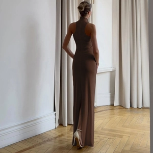 Back view of a slim fit dark brown maxi dress with halter neck and back slit detail