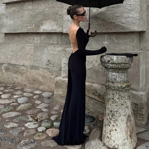 Close-up of backless black maxi dress with delicate metal chain details and ruching