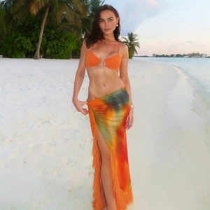 Detailed view of the ruffle hem and side slit on the tie-dye maxi skirt with vibrant colors
