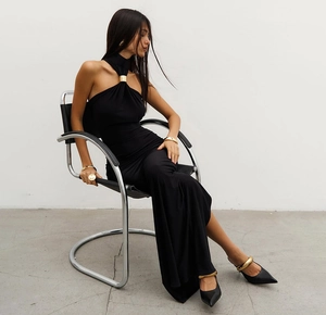 Chic detail of a black halter maxi dress featuring a decorative gold metal ring at the neckline