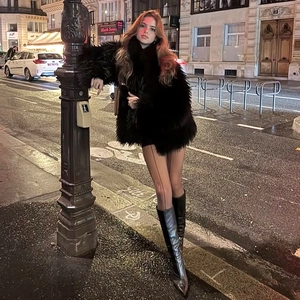 Elegant women's black fluffy faux fur coat paired with shiny over-the-knee leather boots