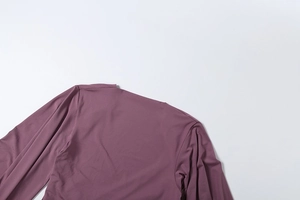 Detailed close-up showing the smooth purple fabric texture and stitching of the romper