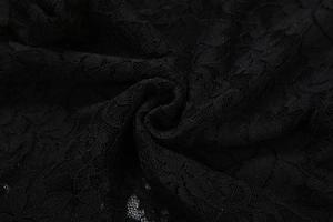 Gros plan sur une dentelle noire délicate aux motifs floraux complexes et structure en maille