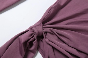 Detail of the twisted knot design on berry purple backless jumpsuit showing neat stitching