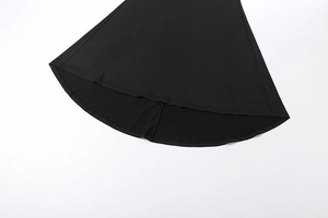 Detail view of the black slim-fit dress featuring an irregular curved hemline design