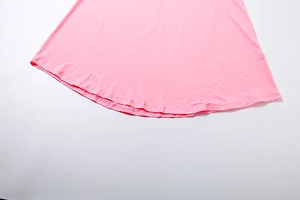 Gros plan détaillé de l'ourlet de la robe longue rose montrant les coutures et le tissu