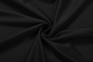 Close-up of black textured fabric with elegant pleated drape for a slim fit dress