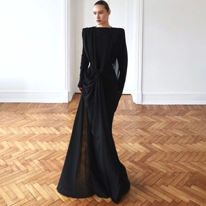Detail of elegant black mesh evening dress featuring padded shoulders and draped pleats