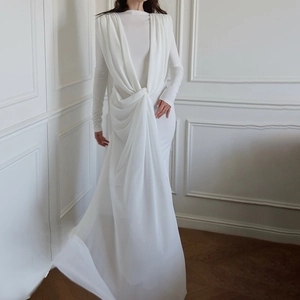Detail of elegant white long sleeve maxi dress featuring twist knot waist and pleated drape