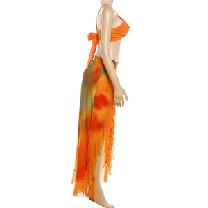 Detailed close-up of the orange tie-dye skirt with tiered ruffles and asymmetrical hemline
