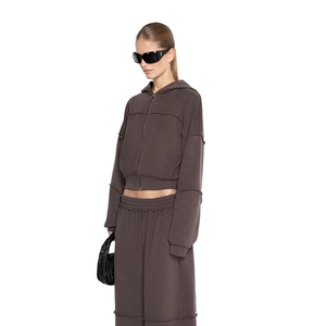 Detail eines kaffeebraunen Lounge-Sets mit Kapuzenjacke und Jogginghose mit offener Naht