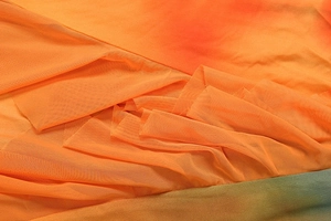 Detail of orange gradient mesh fabric with fine honeycomb texture and pleated finish