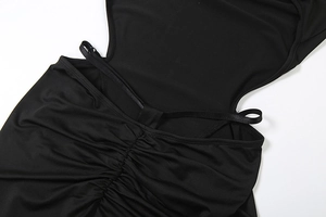 Detail of ruched texture and backless cutout on black stretch long sleeve jumpsuit