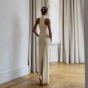 Detail of elegant cream bodycon maxi dress featuring a high halter neck and back slit