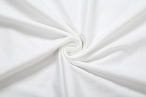 Détail macro du tissu en maille blanche douce montrant une texture lisse et des plis délicats
