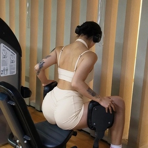 Détail de l'ensemble de yoga beige avec débardeur et short taille haute lors d'un exercice
