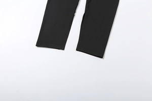 Detail view of double-needle stitching on black elastic knitted jumpsuit hem cuffs