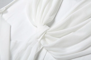 Detailed macro view of twisted white mesh fabric texture on a slim fit dress