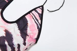 Gros plan du décolleté en V dos nu avec imprimé marbre rose et noir et liens noirs
