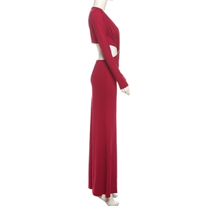 Détail d'une robe longue rouge ajustée avec découpe à la taille et boucle métallique