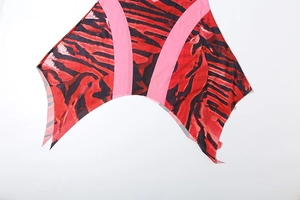 Détail de l'ourlet mouchoir et du motif rouge abstrait sur la robe dos nu