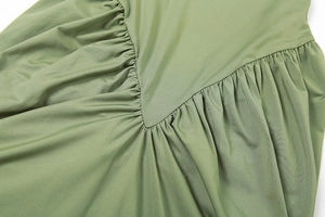 Détail d'une robe vert olive avec fronces en V et texture de tissu plissée