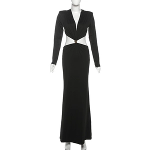Détail d'une robe noire à manches longues avec découpe à la taille et boucle dorée