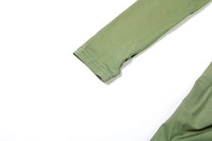 Détail de manche longue vert olive avec trou pour le pouce et coutures plates renforcées