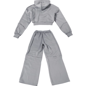 Detail eines grauen Crop-Hoodies und weit geschnittener Jogginghose mit Ziernähten