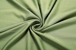 Texture macro de tissu tricoté vert olive avec drapé élégant et doux éclat de soie