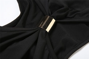 Close-up of black strapless dress featuring a polished gold metallic tube detail and pleats