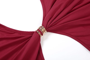 Vue détaillée de la robe rouge montrant le design ajouré et les anneaux en métal doré