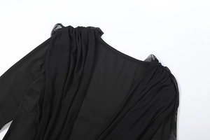 Detail view of the elegant square neckline and ruffled shoulder pleats on the black mesh dress