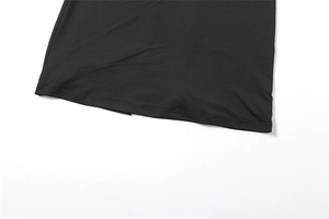 Detail of neatly stitched hemline and knit fabric texture on a black tube maxi dress