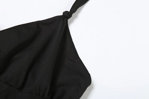 Détail macro du nœud élégant et du décolleté dos nu sur un body noir sophistiqué