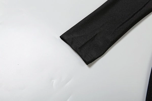 Détail d'une combinaison noire montrant le tissu élégant et les coutures aux bords