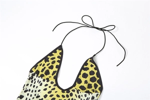 Détail macro d'une robe dos nu imprimé léopard avec liens noirs et finitions de couture