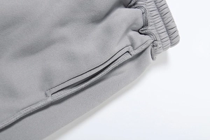 Detail des elastischen Bunds und der Seitentaschen bei grauen Strick-Jogginghosen
