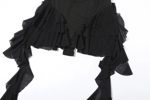Détail des volants en tulle multicouches et fermeture par boutons-pression du body noir