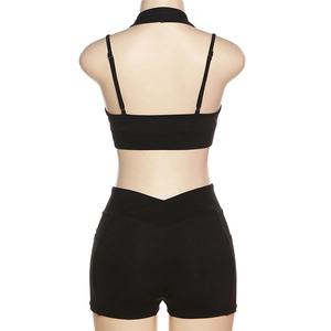 Détail d'un ensemble de yoga noir avec brassière et short à taille en V sur mannequin