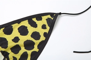 Détail macro du bikini imprimé léopard jaune avec coutures et passepoil noir de qualité