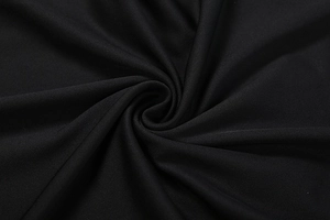 Macro detail of high-quality black mesh fabric texture showing elegant spiral drapes