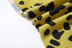Détail du tissu à imprimé léopard jaune avec texture côtelée et drapé fluide