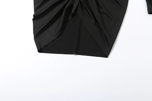 Détail du nœud élégant et du plissé sur une robe courte noire à manches longues