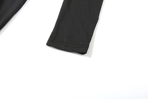 Détail du poignet avec double piqûre d'une robe en maille noire à manches longues