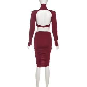 Détail d'un ensemble en tricot bordeaux avec haut dos nu à manches longues et mini-jupe