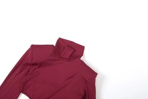 Détail d'un body bordeaux à col roulé montrant la maille fine et la couture épaule