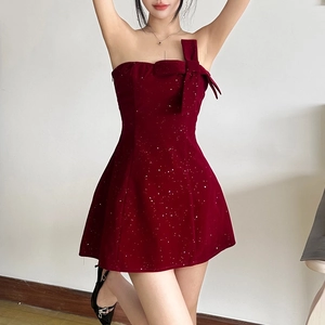 Détail d'une robe bustier bordeaux ornée de paillettes argentées et d'un gros nœud