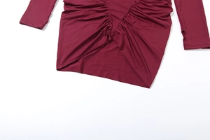 Détail de la robe bordeaux avec fronces, montrant la couture en V et la texture du tissu